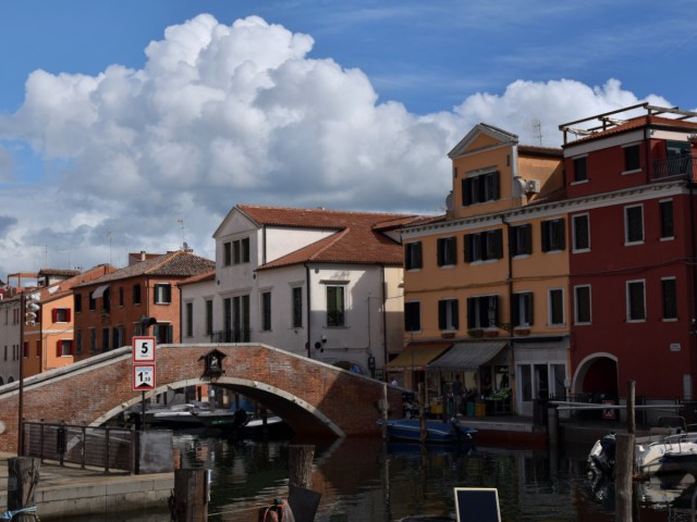 Colorful houses with bridge over the main channel in sunny weather at Chioggia, Italy.