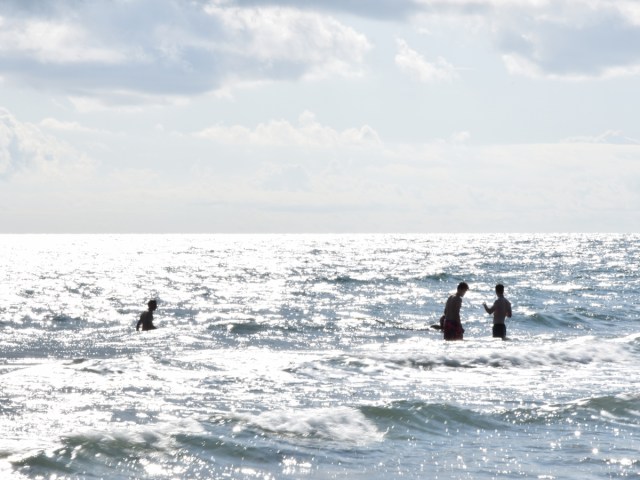 People having fun in the water at the beach in Chioggia, Italy in sunny weather.